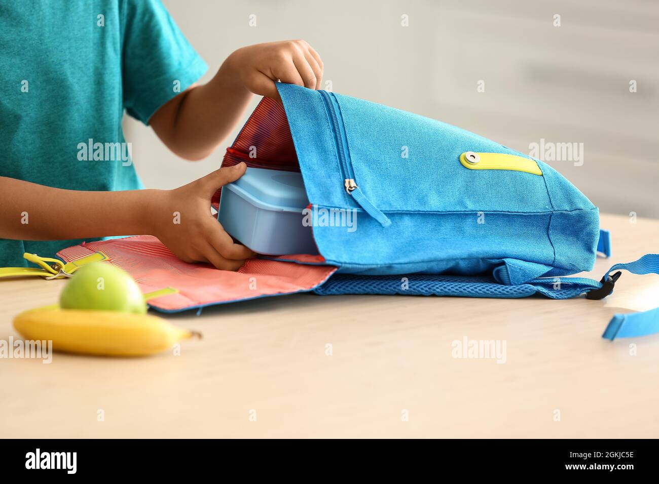 Cute little boy putting his school lunch in bag Stock Photo