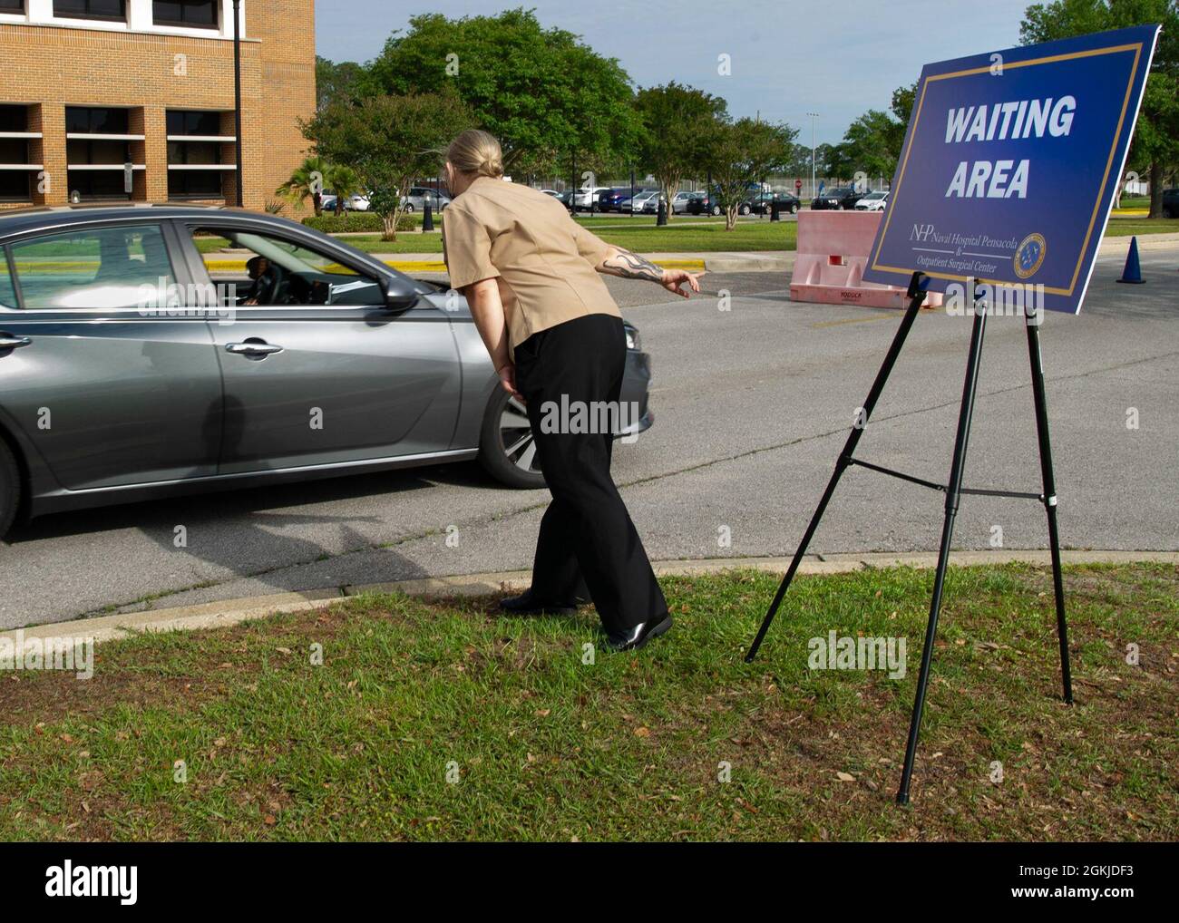 PENSACOLA, Fla. (May 1, 2021) Hospitalman Mary Reynolds, a native of Blountstown, Florida, directs patients to the waiting area where they are monitored for 15 minutes after they have received a COVID-19 vaccination during a drive-thru COVID-19 vaccine clinic at Naval Hospital Pensacola. The drive-thru vaccination clinic was prepared to provide a COVID-19 vaccine to more than 600 TRICARE beneficiaries age 16 and older. Stock Photo