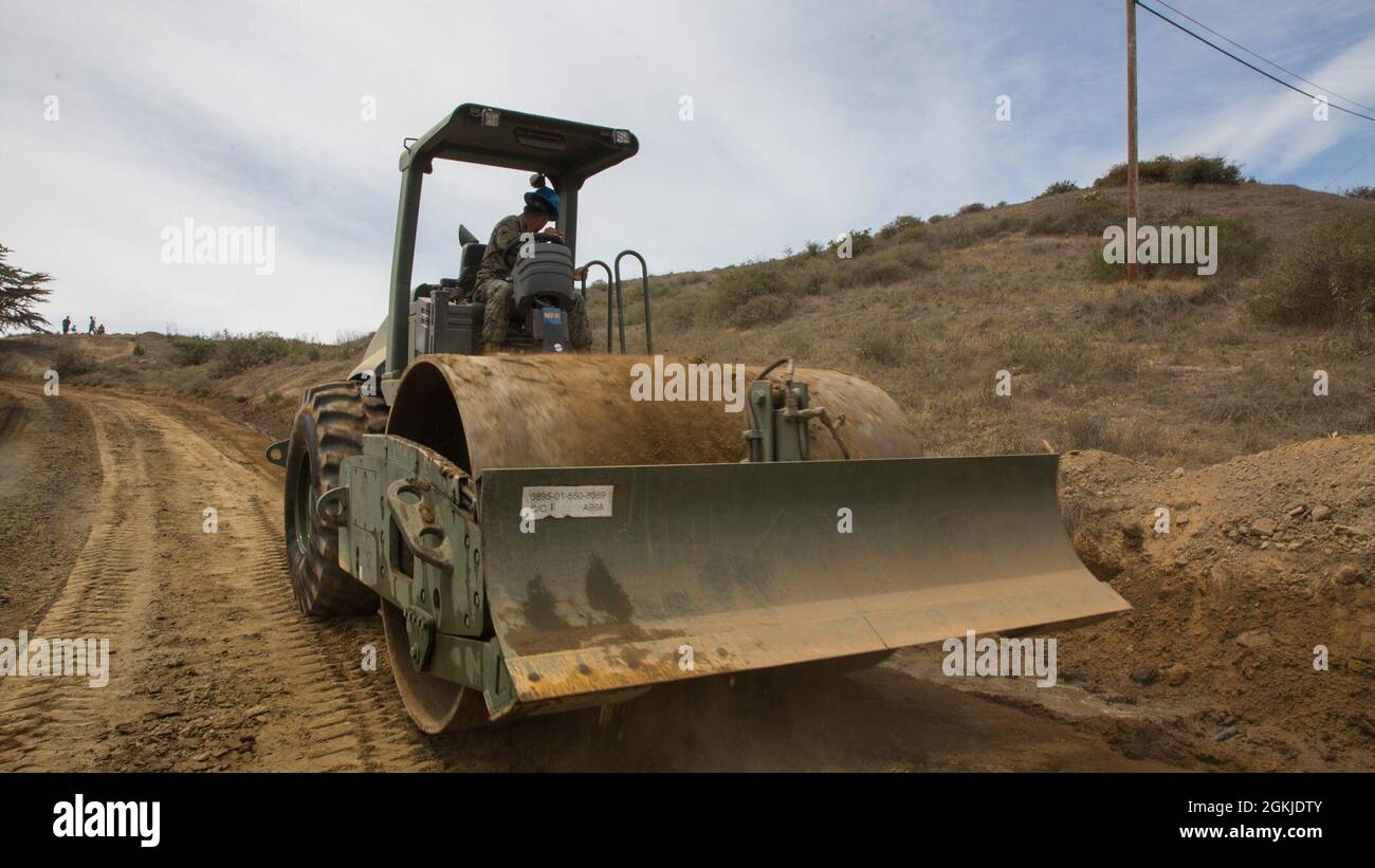 U.S. Marine Corps Lance Cpl. Jorge Chavez, a heavy equipment operator with Marine Wing Support Squadron (MWSS) 373, Marine Aircraft Group 11, 3rd Marine Aircraft Wing, operates a compactor during road repairs on Santa Catalina Island, California, May 1, 2021. Operational readiness and quick adapting nature allows MWSS-373 to work efficiently on culverts and roads, while maneuvering the mountainous terrain showcasing how Marines overcome their obstacles and adapt to their surroundings. Stock Photo