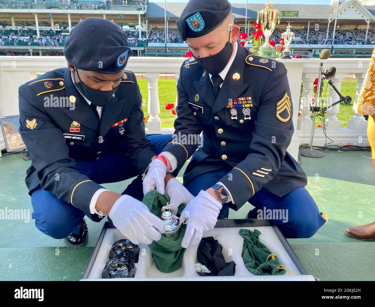 Spc. Christian Banks-Mitchell (left) and Staff Sgt. Andy Thum unwrap a Kentucky Derby Trophy in the Winners' Circle of Churchill Downs prior to the running of the race in Louisville, Ky., May 1, 2021. Nearly 100 Kentucky National Guard Soldiers and Airmen supported local authorities for the 147th running of the Kentucky Derby. Stock Photo