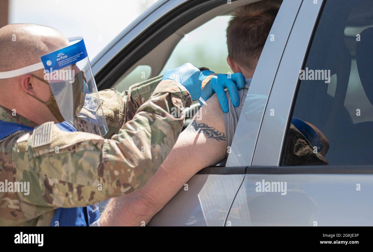 U.S. Army Sgt. Casey Bergmann, a combat medic assigned to 2nd Stryker Brigade Combat Team, 4th Infantry Division, administers a vaccination at the Community Vaccination Center (CVC) at the Colorado State Fairgrounds in Pueblo, Colorado, May 2, 2021. Bergmann deployed from Fort Carson, Colorado, to provide whole-of-government support at the Pueblo Community Vaccination Site. U.S. Northern Command, through U.S. Army North, remains committed to providing continued, flexible Department of Defense support to the Federal Emergency Management Agency as part of the whole-of-government response to COVI Stock Photo