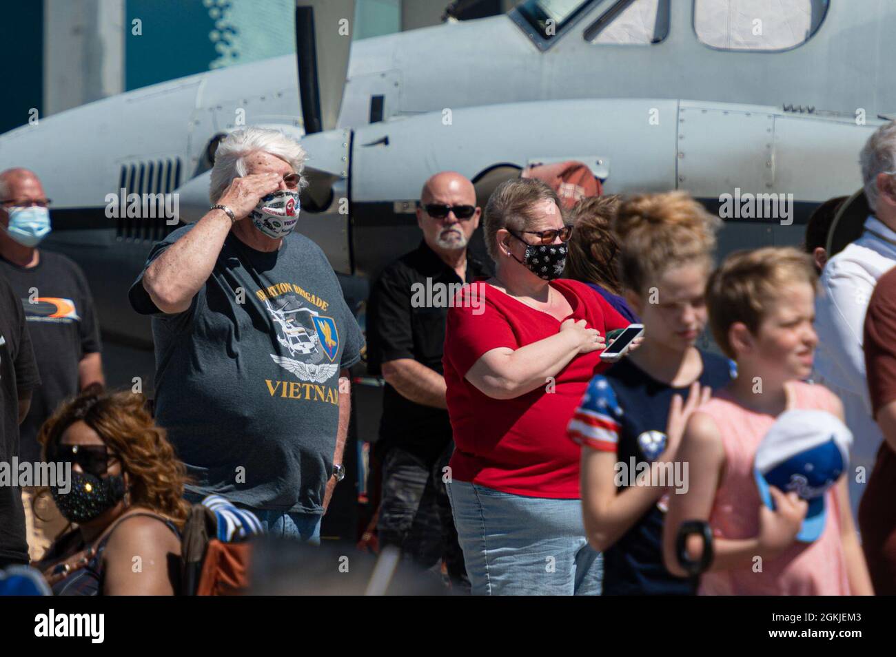 A military veteran salutes during the playing of the national anthem