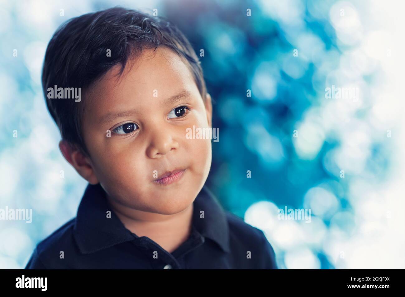 A boy in a state of mind that reflects thoughtful thinking, considering choices and who is looking away into the distance with his head slightly tilte Stock Photo