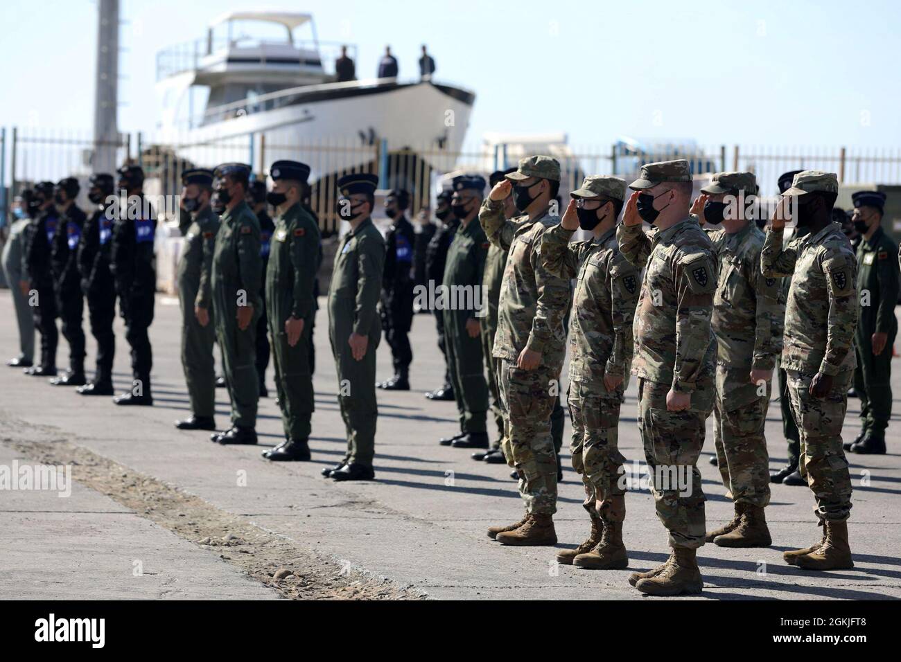U.S. Army Soldiers, standing beside Albanian military partners, salute the flag May 2, 2021, during the opening DEFENDER-Europe 21 exercises at the Port of Durres, Albania. During the operations, Joint Forces, working alongside multinational allies and partners, unloaded thousands of pieces of equipment and supplies that will be forwarded to troops in the field participating in training throughout the European theater.  DEFENDER-Europe 21 is a large-scale U.S. Army-led exercise designed to build readiness and interoperability between the U.S., NATO allies and partner militaries. This year, mor Stock Photo