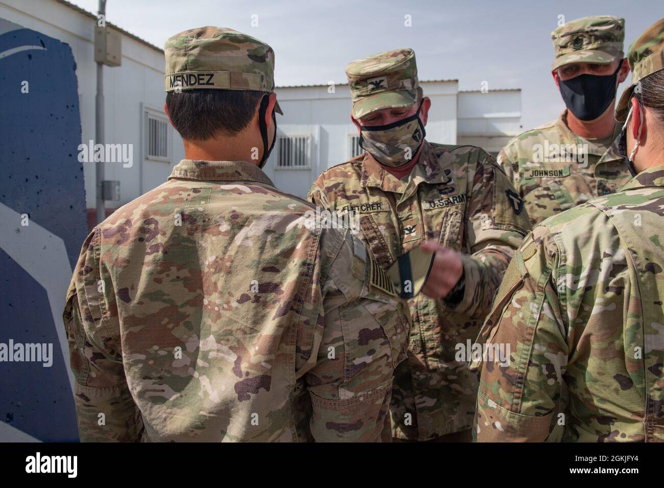 Task Force Spartan Division Tactical- Jordan, Officer in Charge, Col. Christopher Fletcher, must really fight to give U.S. Army Maj. Chris Mendez his right sleeve T-Patch during a ceremony hosted by the Col. and Sgt. Maj. Daniel Johnson at the Joint Training Center in Jordan, May 3, 2021. Brig. Gen. Win Burkett, Task Force Spartan Assistant Commanding General- Operations spoke a few words commemorating the special day for each of the recipients. Stock Photo