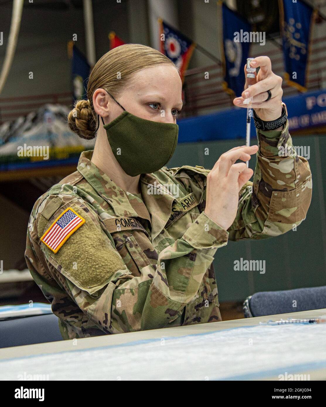Pfc. Shannon Comeaux from Charlie Company, 210 Brigade Support Battalion, 2nd Brigade Combat Team, 10th Mountain Division (LI) carefully fills a syringe with COVID-19 vaccine at a vaccine dispersal site at Magrath gym on Fort Drum, May 3, 2021. Fort Drum Soldiers have been receiving COVID-19 vaccines in increasing numbers since initial vaccine dispersal. Stock Photo