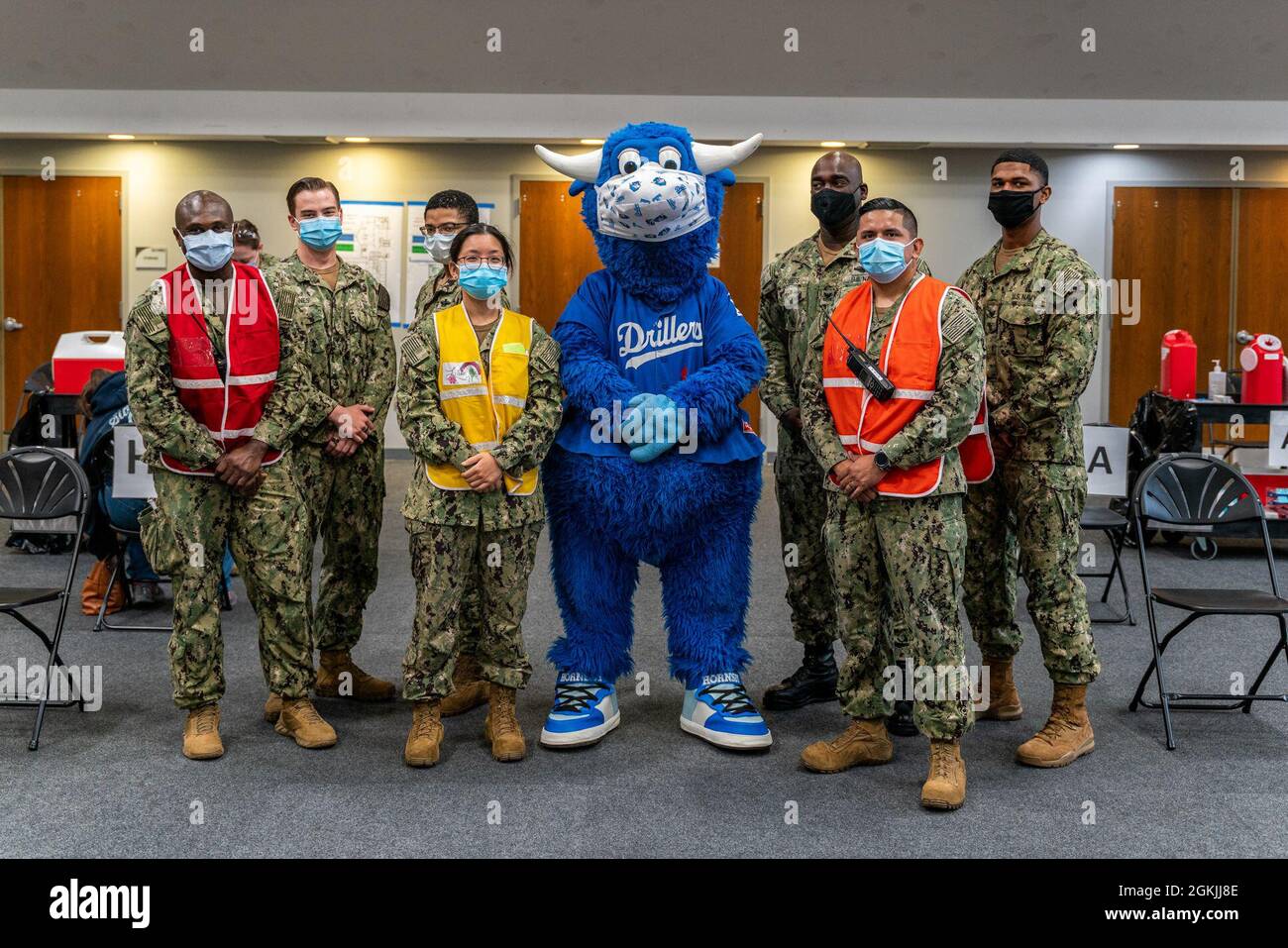 U.S. Navy Sailors assigned to the Naval Medical Readiness Training Command (NMRTC) San Diego pose with the Tulsa Drillers mascot, Hornsby the Bull, during his tour of the Community Vaccination Center (CVC) at the Tulsa Community College Northeast Campus in Tulsa, Oklahoma, May 5, 2021. Sailors assigned to NMRTC San Diego will support daily vaccination operations at the Tulsa CVC. U.S. Northern Command, through U.S. Army North, remains committed to providing continued, flexible Department of Defense support to the Federal Emergency Management Agency as part of the whole-of-government response t Stock Photo
