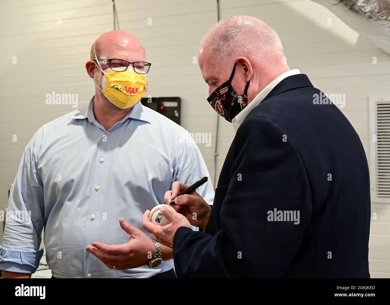 Maryland Governor Larry Hogan signs a baseball for a member of the medical team  during a visit to the Ripken Stadium vaccination site on May 5, 2021, in Aberdeen, Maryland. The site offers drive-up vaccinations to assist citizens in Harford County with increased vaccination options. Stock Photo