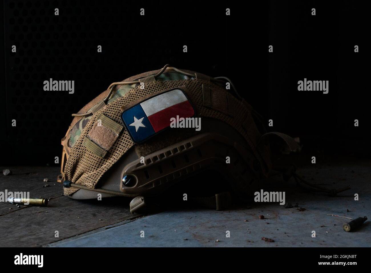 A helmet laid down in a shipping container, surrounded by spent simunition rounds at Cannon AFB, N.M., May 7, 2021. The primary function of a helmet is to protect the wearer’s head from traumatic injuries, as well as provide a platform for various pieces of equipment such as lights and night vision. CASEVAC training mimics real-world operations in potentially hostile environments, requiring service members to wear full protective gear to ensure safety at all times. Stock Photo