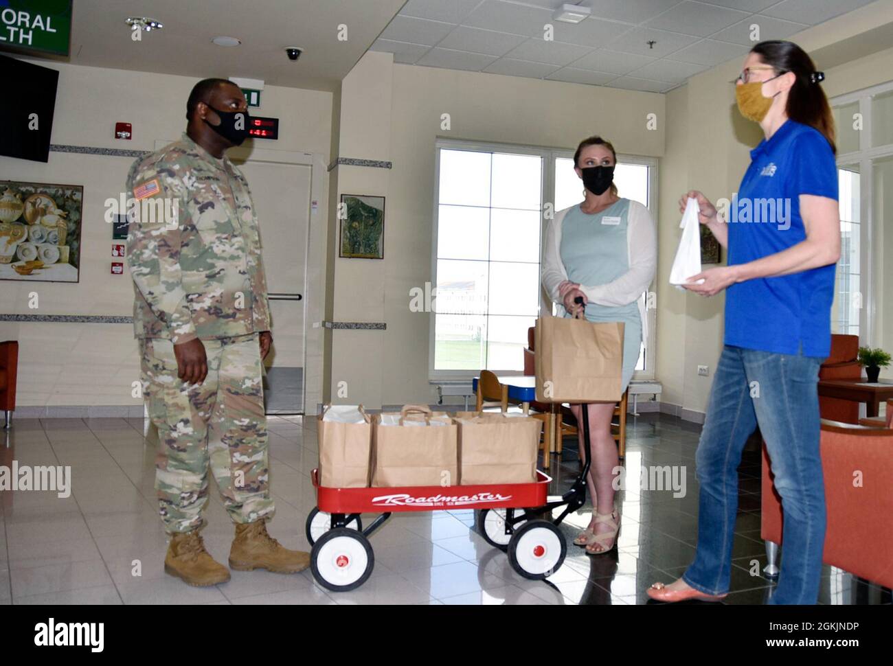 VICENZA, Italy - Sgt. Deron Thompson, behavioral health at the U.S. Army Health Center, Vicenza, receives some ‘Resiliency through Art’ individual kits May 5, 2021, by Michelle Sterkowicz, U.S. Army Garrison Italy Art Center program manager, (right) and Aurora Venden, American Red Cross Interim Regional program manager.  The Art Center worked in partnership with volunteers and organizations to deliver approximately 700 kits to help discover the benefits of art during COVID-19. Stock Photo