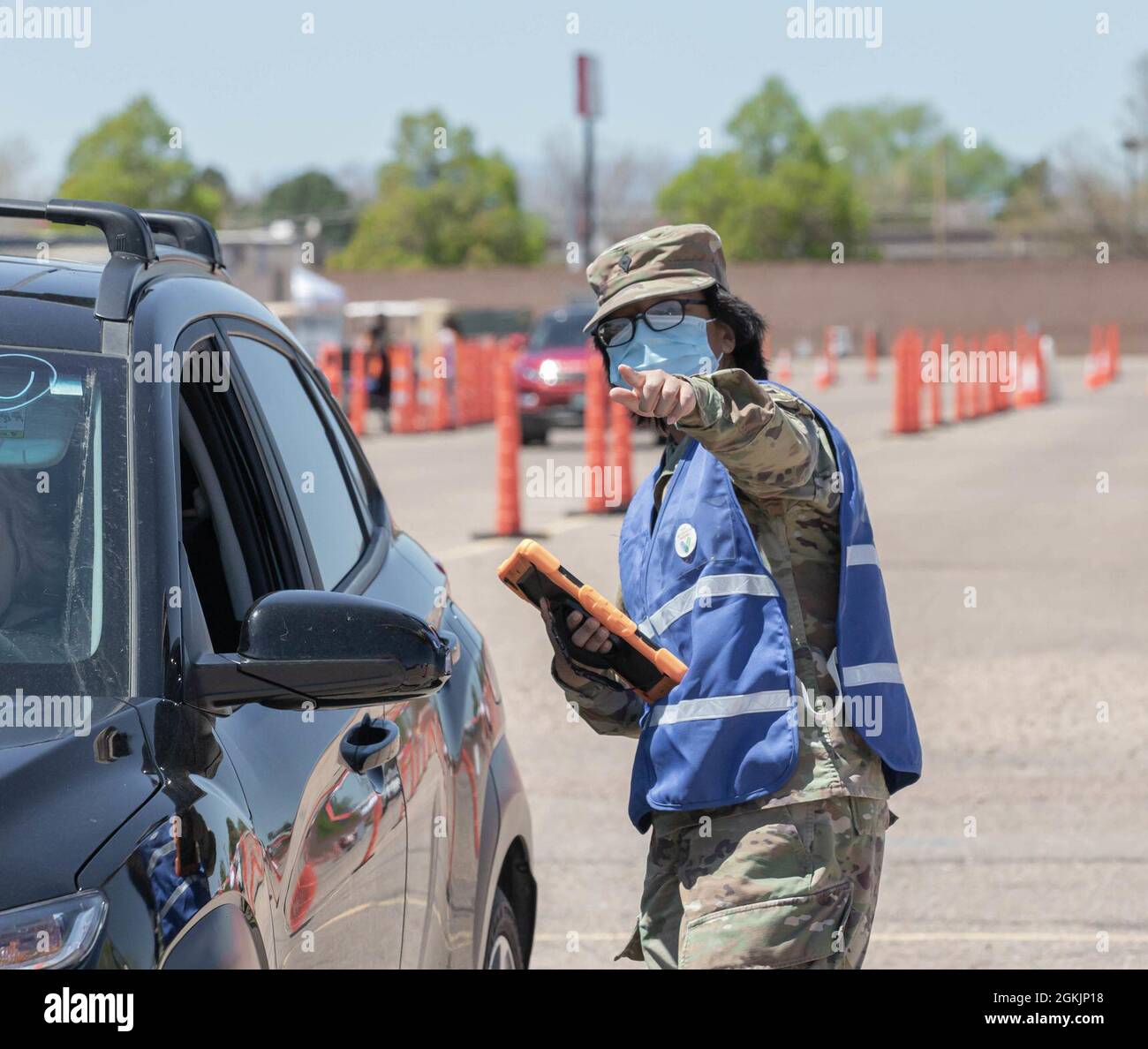 U.S. Army Spc. Omega Toledo, a combat medic assigned to 2nd Stryker Brigade Combat Team, 4th Infantry Division, directs a community member to their lane at the Community Vaccination Center at the Colorado State Fairgrounds in Pueblo, Colorado, May 6, 2021. The Soldier from Fort Carson, Colorado, support the federal vaccination mission in Pueblo, Colorado. U.S. Northern Command, through U.S. Army North, remains committed to providing continued, flexible Department of Defense support to the Federal Emergency Management Agency as part of the whole-of-government response to COVID-19. Stock Photo