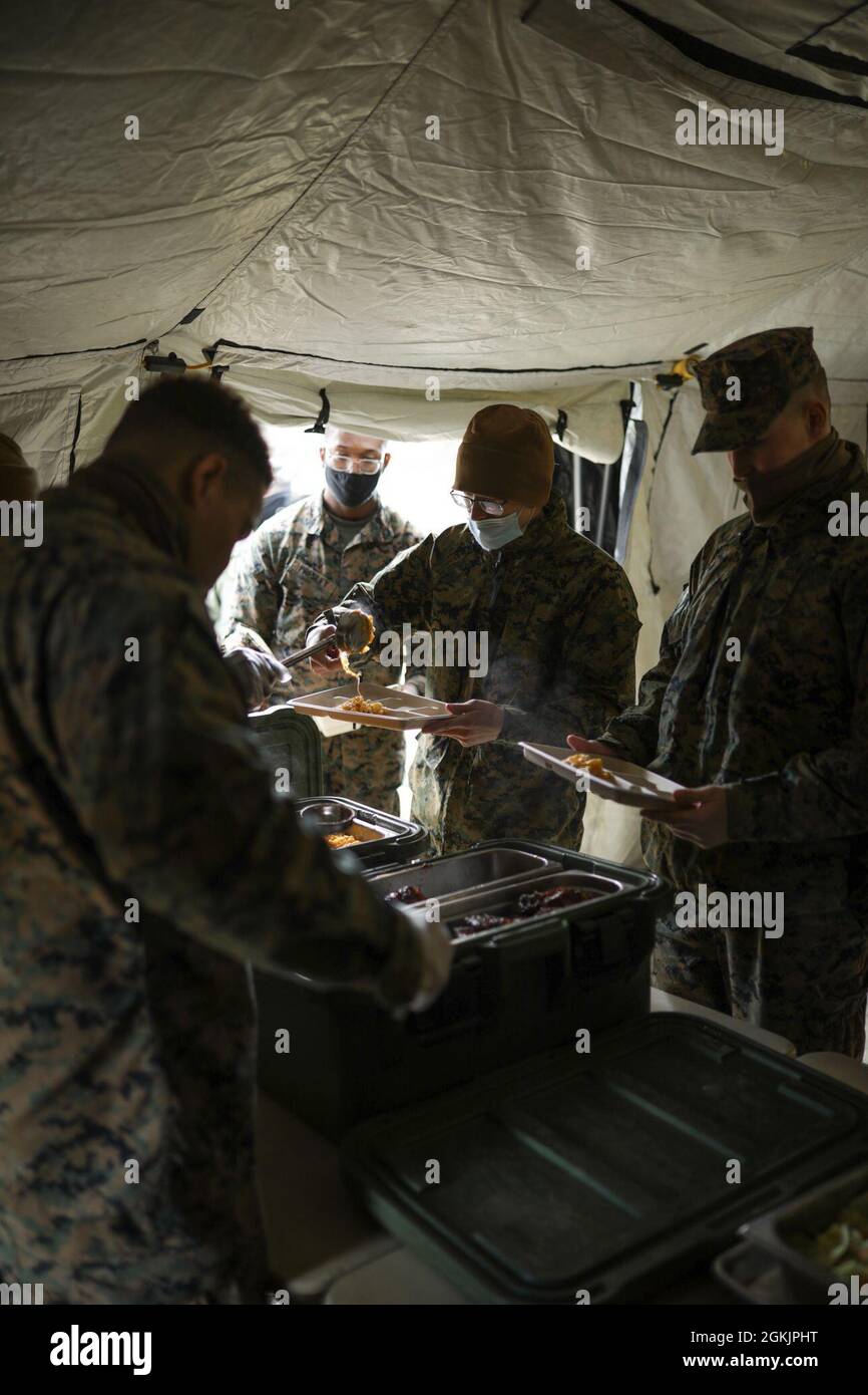 U.S. Marines participating in Arctic Care 2021 receive chow prepared by food service specialists with Combat Logistics Regiment 45, 4th Marine Logistics Group, during Arctic Care 2021 in Kodiak, Alaska, on May 6, 2021. Arctic Care 2021 is a joint-service training mission led by the United States Air Force and supported by members of the Air National Guard, Marines, Marine Reserves, Navy, Navy Reserves, National Guard, and Army Reserves. Stock Photo