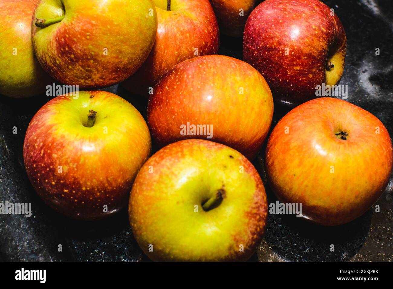 Healthy apples placed on the table for consumption. Apples grow on small, deciduous trees that bloom in spring and produce fruit in autumn. Stock Photo