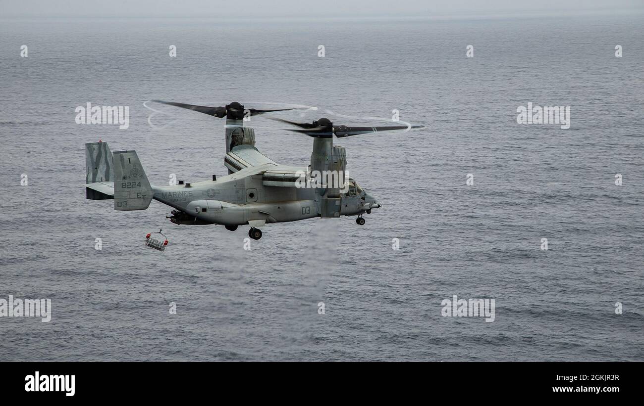 A U.S. Marine Corps MV-22B Osprey assigned to Marine Medium Tiltrotor Squadron (VMM) 262, performs hoist operations off the coast of Ie Shima, Okinawa, Japan, May 6, 2021. Hoist operations were conducted in order to train crew and pilots to conduct specialized contingency missions. Stock Photo