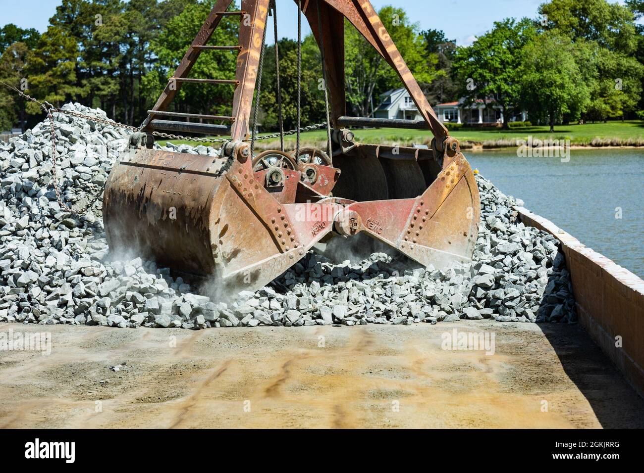 A clamshell bucket begins to pick up rocks from a barge to place in the Tred Avon River Oyster Sanctuary in Talbot County, Maryland May 6, 2021. Stock Photo