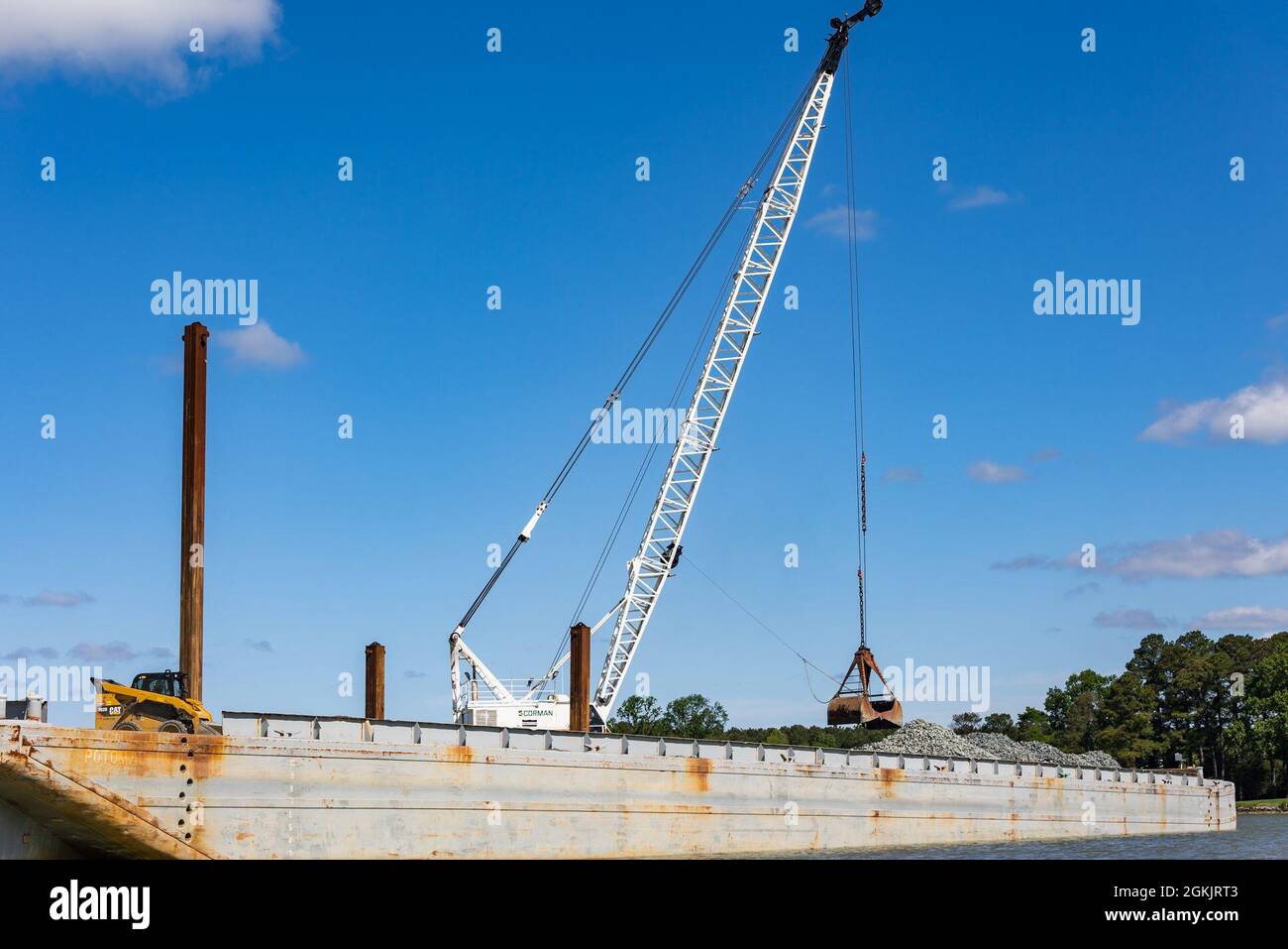 A clamshell bucket moves to pick up rocks from a barge to place in the Tred Avon River Oyster Sanctuary in Talbot County, Maryland May 6, 2021. Stock Photo