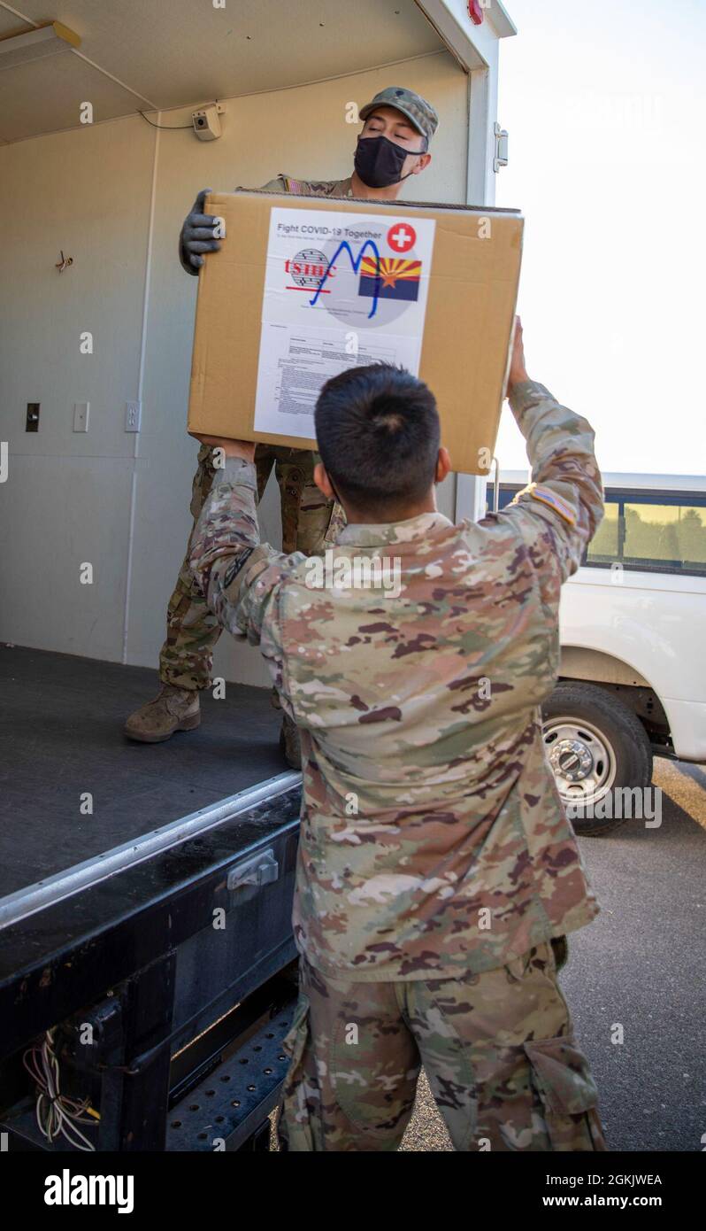 Arizona Army National Guard Soldiers help move personal protective equipment from metal storage