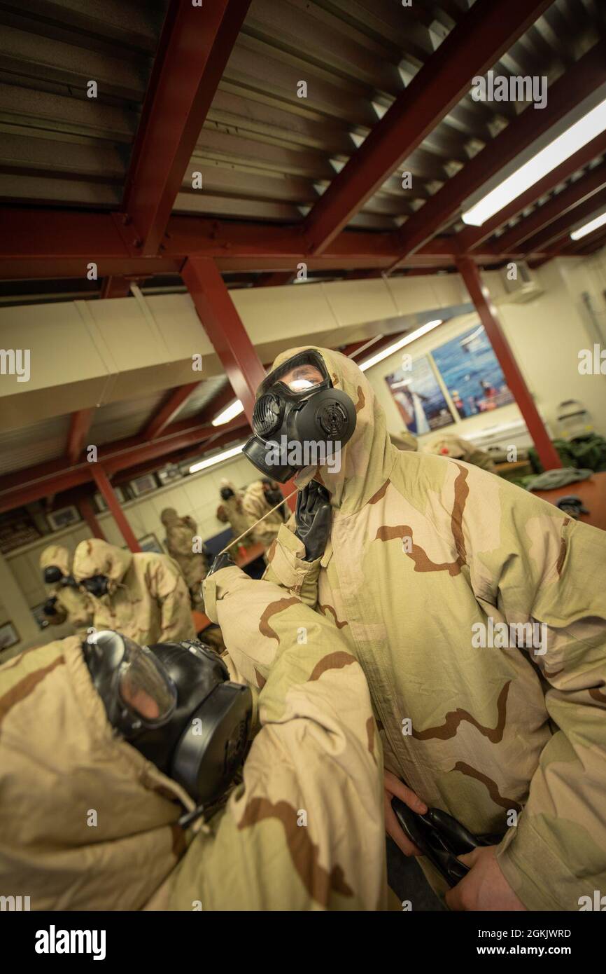 U.S. Marines don Mission Oriented Protective Posture (MOPP) gear for Chemical, Biological, Radiological, and Nuclear (CBRN) defense training during Arctic Care 2021 in Kodiak, Alaska, on May 7, 2021. Arctic Care 2021 is a joint-service training mission led by the United States Air Force and supported by members of the Air National Guard, Marines, Marine Reserves, Navy, Navy Reserves, National Guard, and Army Reserves. Stock Photo