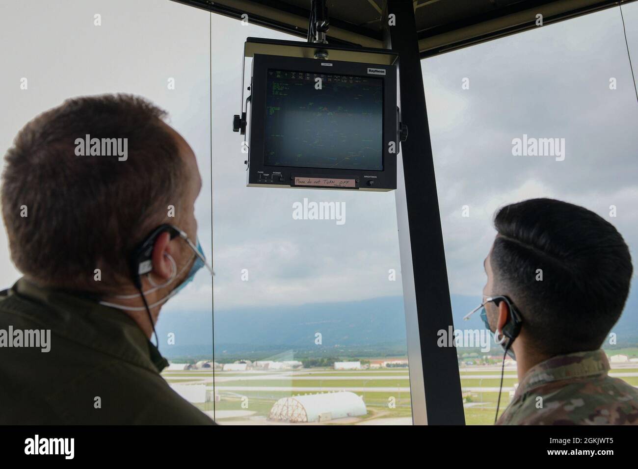 Italian air force Maresciallo Francesco Di Maggio, Servizio CSA,  Air Traffic Control Service, air traffic controller (ATC), left, and U.S. Air Force Staff Sgt. Daniel Cabezas, 31st Operations Support Squadron (OSS) ATC, review flight data in the Air Traffic Control Tower at Aviano Air Base, Italy, May 7, 2021. ATCs plot aircraft positions on radar equipment and compute aircraft speed, direction and altitude. The U.S. Air Force and ITAF ATCs work together to relay flight and landing instructions, weather updates, and safety information to the pilots. Stock Photo