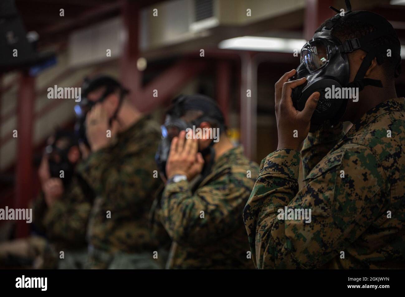 U.S. Marines check the seal of their M50 joint service general purpose masks for Chemical, Biological, Radiological, and Nuclear (CBRN) defense training during Arctic Care 2021 in Kodiak, Alaska on May 7, 2021. Arctic Care 2021 is a joint-service training mission led by the United States Air Force and supported by members of the Air National Guard, Marines, Marine Reserves, Navy, Navy Reserves, National Guard, and Army Reserves. Stock Photo