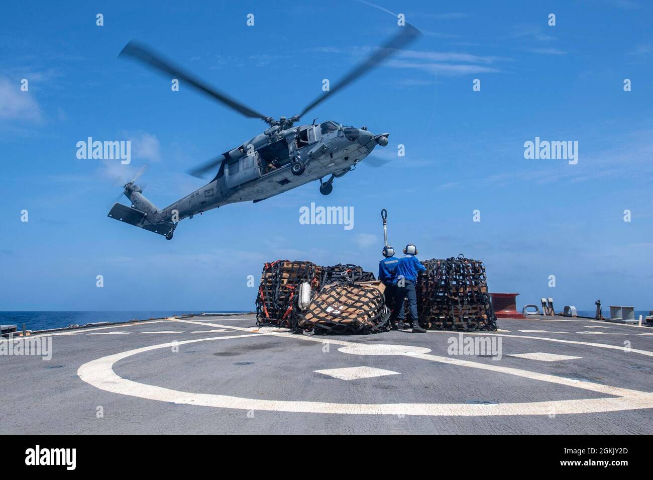 ARABIAN SEA (May 8, 2021) – Boatswain’s Mate 3rd Class Nathaniel Yost, left, and Gas Turbine System Technician (Mechanical) 3rd Class Jason Bird, both assigned to guided-missile destroyer USS Laboon (DDG 58), prepare to attach cargo to a MH-60S Sea Hawk helicopter, attached to the “Dusty Dogs” of Helicopter Sea Combat Squadron 7, during a vertical replenishment-at-sea in the Arabian Sea, May 8. Laboon is operating with the IKE Carrier Strike Group while deployed to the U.S. 5th Fleet area of operations in support of naval operations and providing air power to protect U.S. and coalition forces Stock Photo
