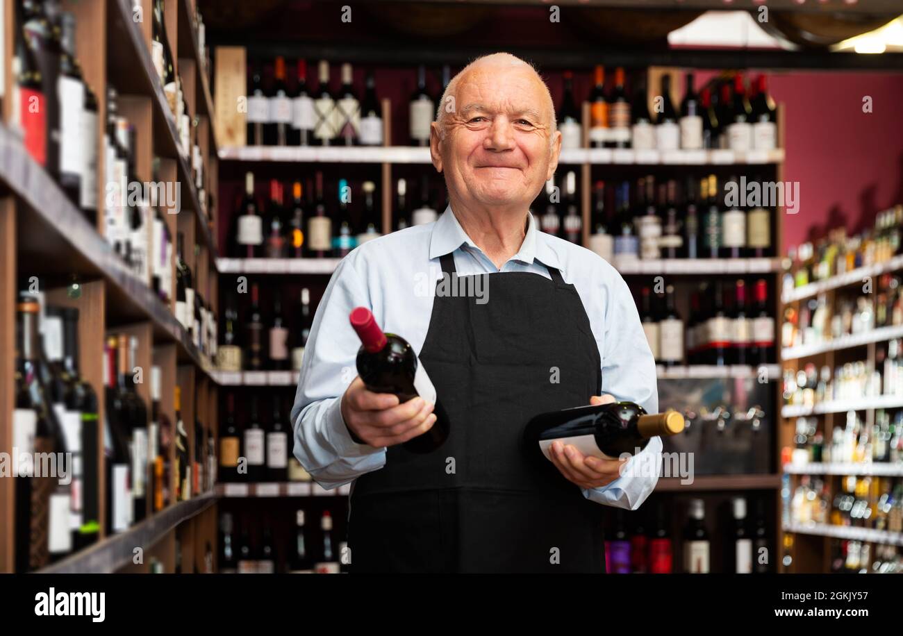 vintner offering wine in modern wineshop Stock Photo