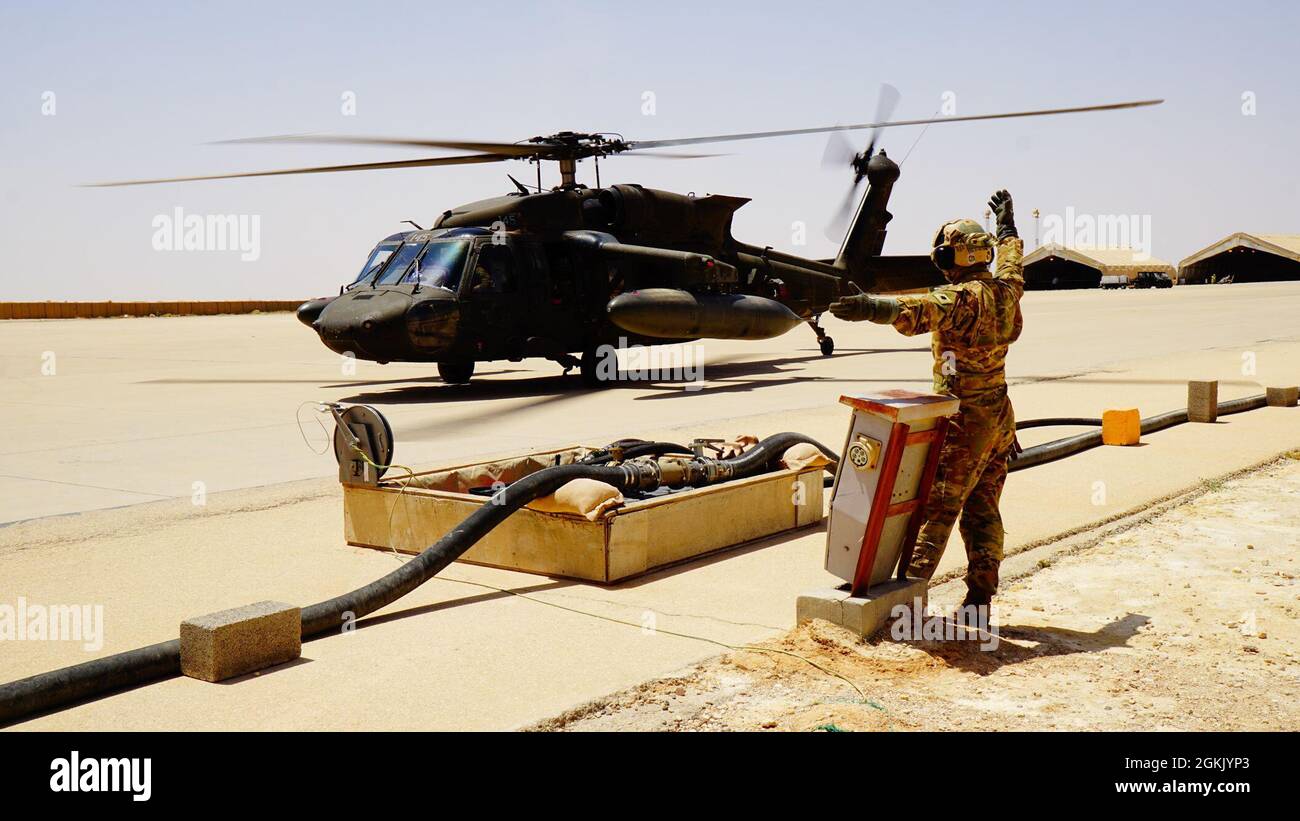 Spc. Er Milliam Caparas directs a UH-60 Black Hawk helicopter into position for hot refueling. Stock Photo
