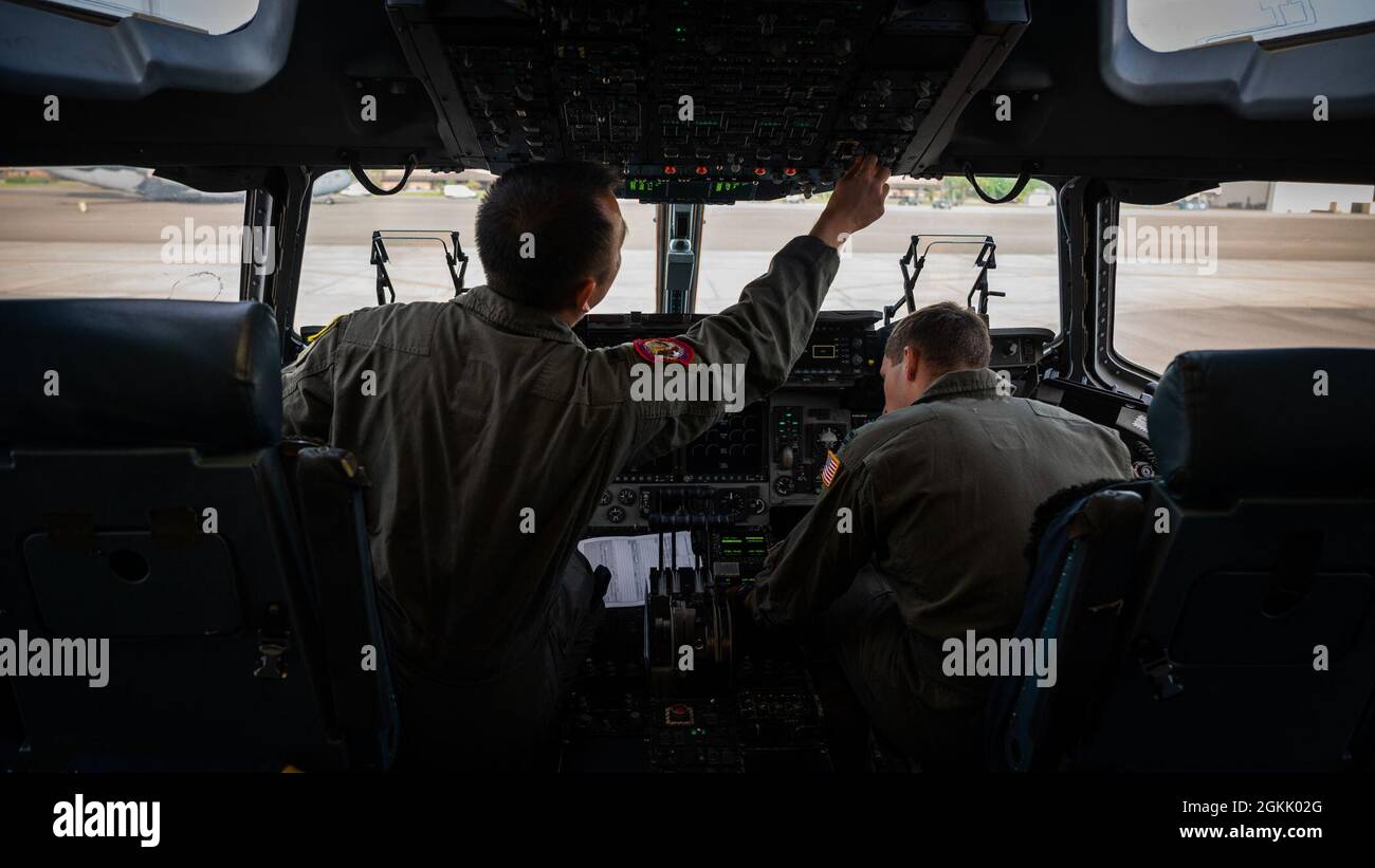 U.S. Air Force 1st Lt. James Xiong, left, and U.S. Air Force Capt. James Schackelton, copilots assigned to the 15th Airlift Squadron, conduct preflight checks in a C-17 Globemaster III at Joint Base Charleston, South Carolina, May 10, 2021. Aircrew members conducted low-level operations and deployed combat offload packages to hone global mobility readiness. Stock Photo