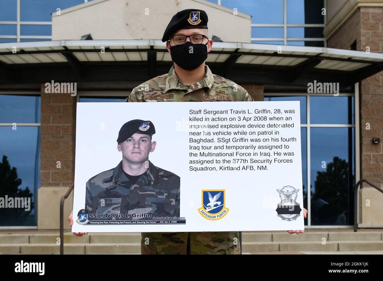 An Airman from the 460th Security Forces Squadron holds up a poster on Buckley Air Force Base, Colo., May 10, 2021, containing the story of Staff Sgt. Travis L. Griffen, a 377th Security Forces Squadron defender, who was killed during his fourth Iraq tour. During National Police Week, Security Forces Airmen gave tribute to their brothers and sisters who have lost their lives in the line of duty for the safety and protection of others. Stock Photo