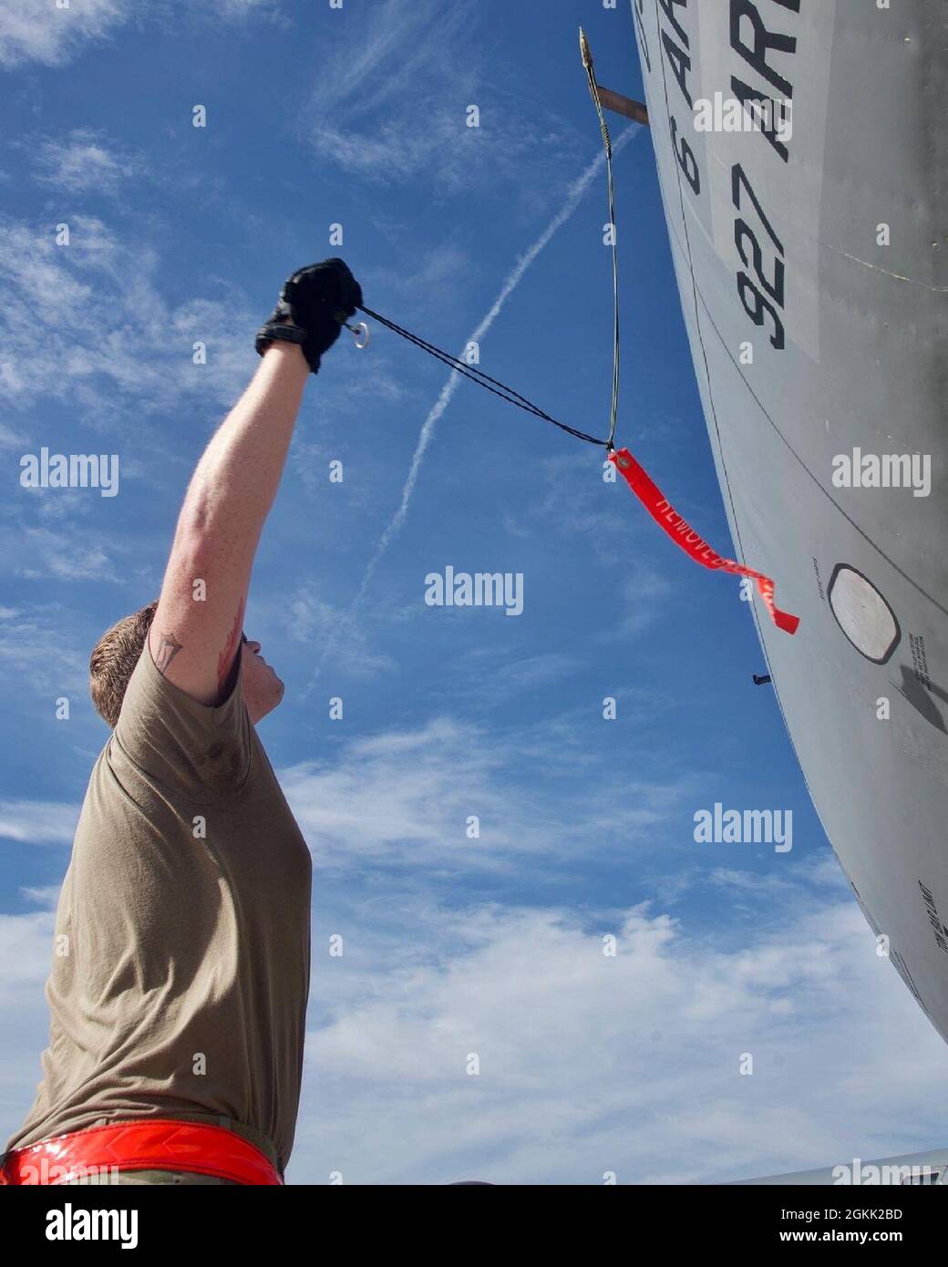 A U.S. Air Force crew chief, with the 6th Air Refueling Wing, pulls the pitot tube cover off a KC-135 Stratotanker on MacDill Air Force Base, Florida on May 10, 2021.  The cover is designed to prevent debris or bugs from entering the pitot tube while the airplane is parked. Stock Photo