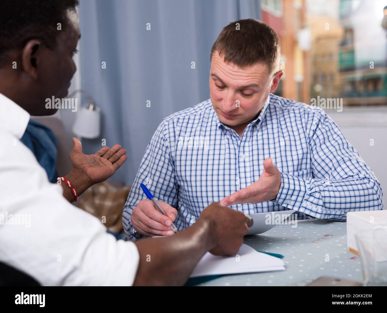 Two serious men analysing documents at home Stock Photo