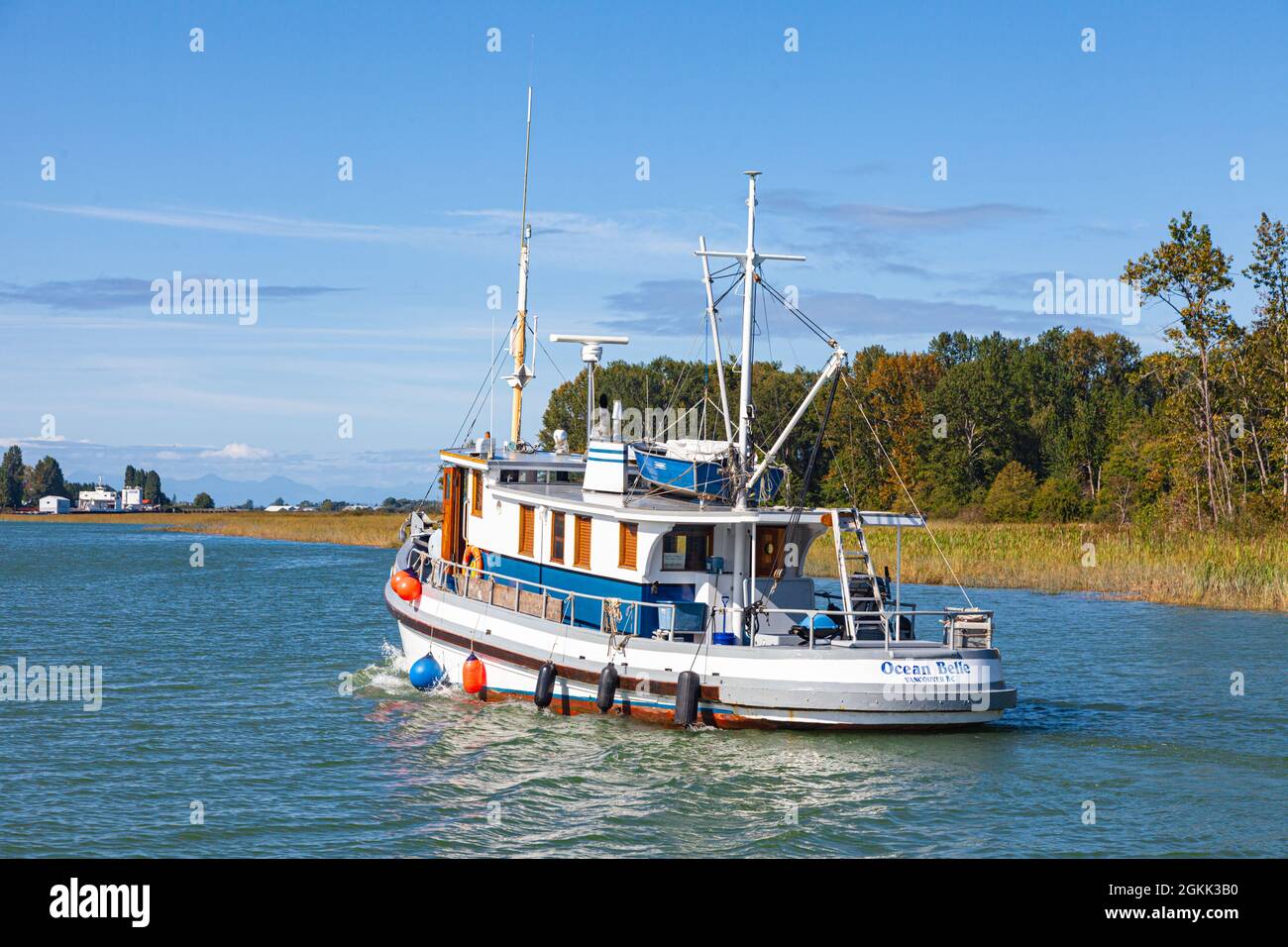 Pleasure craft cruising one of the channels of the Fraser River delta near Ladner British Columbia Canada Stock Photo