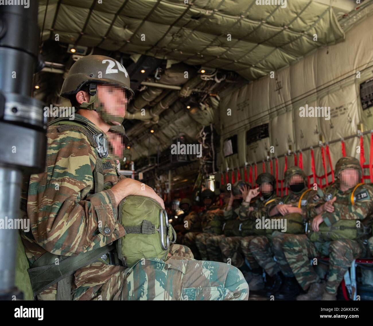 Hellenic armed forces and U.S. military members wait for departure aboard a C-130J Super Hercules aircraft assigned to the 37th Airlift Squadron during Operation Stolen Cerberus at Elefsis Air Base, Greece, May 11, 2021. Members of the 435th Contingency Response Group accompanied Hellenic forces during a static line jump as part of a bi-lateral training event. Stock Photo