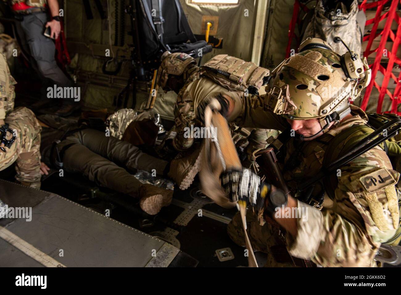 A U.S. Air Force Airman from the 57th Rescue Squadron prepares to secure a gurney while other members treat a simulated patient in-flight as part of Operation Stolen Cerberus VIII at Elefsis Air Base, Greece, May 12, 2021. The Hellenic armed forces participated in the scenario, which served to strengthen interoperability cohesion. The training reinforces the Agile Combat Employment capabilities of Hellenic armed forces and U.S. military members who operate with varying levels of support and resources. Stock Photo
