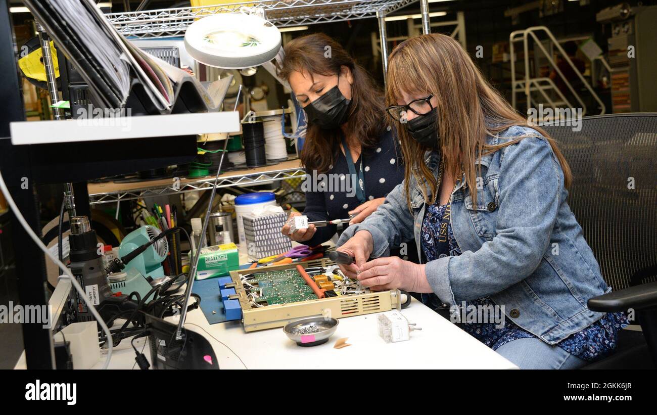 210512-N-UN340-027 SAN DIEGO (May 12, 2021) Naval Information Warfare Center Pacific (NIWC Pacific) Electronics Technican/Integrators Becky Phommavong, left, and Julieta Haralson assemble components of Consolidated Afloat Ships Network Enterprise Services (CANES) racks in NIWC Pacific’s Network Integration and Engineering Facility. Stock Photo