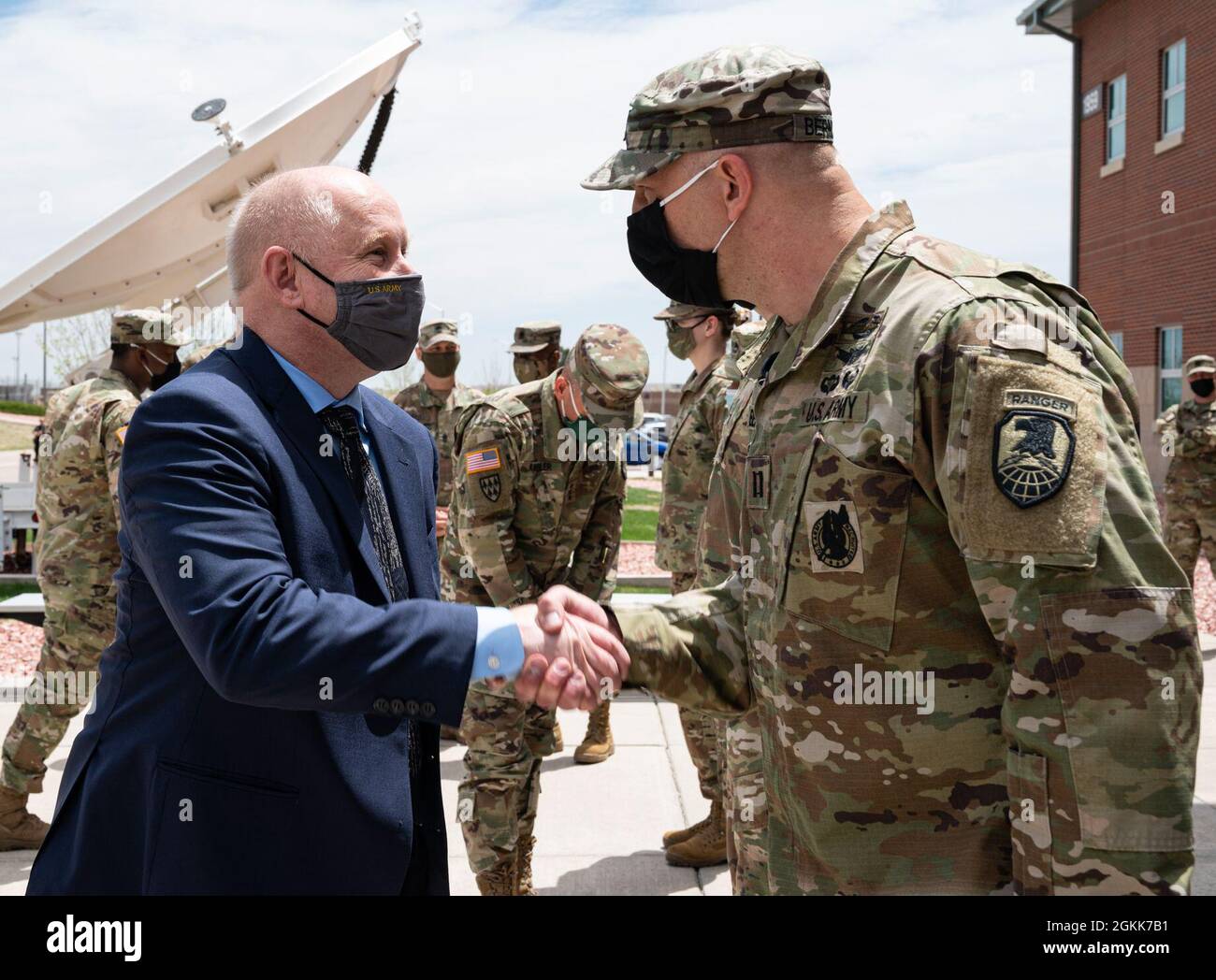Acting Secretary of the Army Hon. John E. Whitley presents a challenge coin to  Capt. Gideon Bernthal for his hard work in planning the Secretary's visit to U.S. Army Space and Missile Defense Command units at Fort Carson, Colo., May 13, 2021. Stock Photo