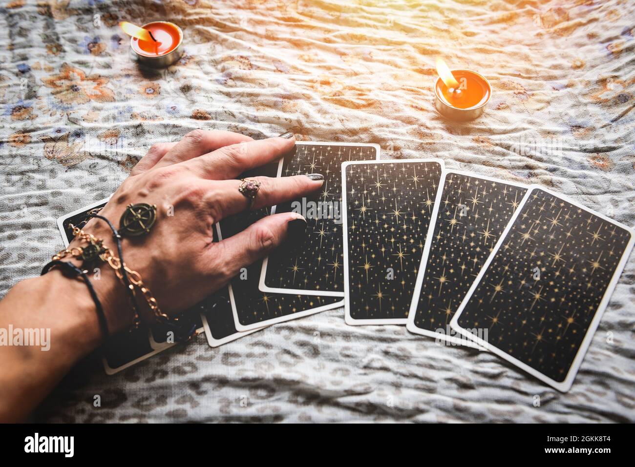 Show fortune tellers of hands holding tarot cards and tarot reader with candle light on the table, Performing readings magical performances, Things my Stock Photo