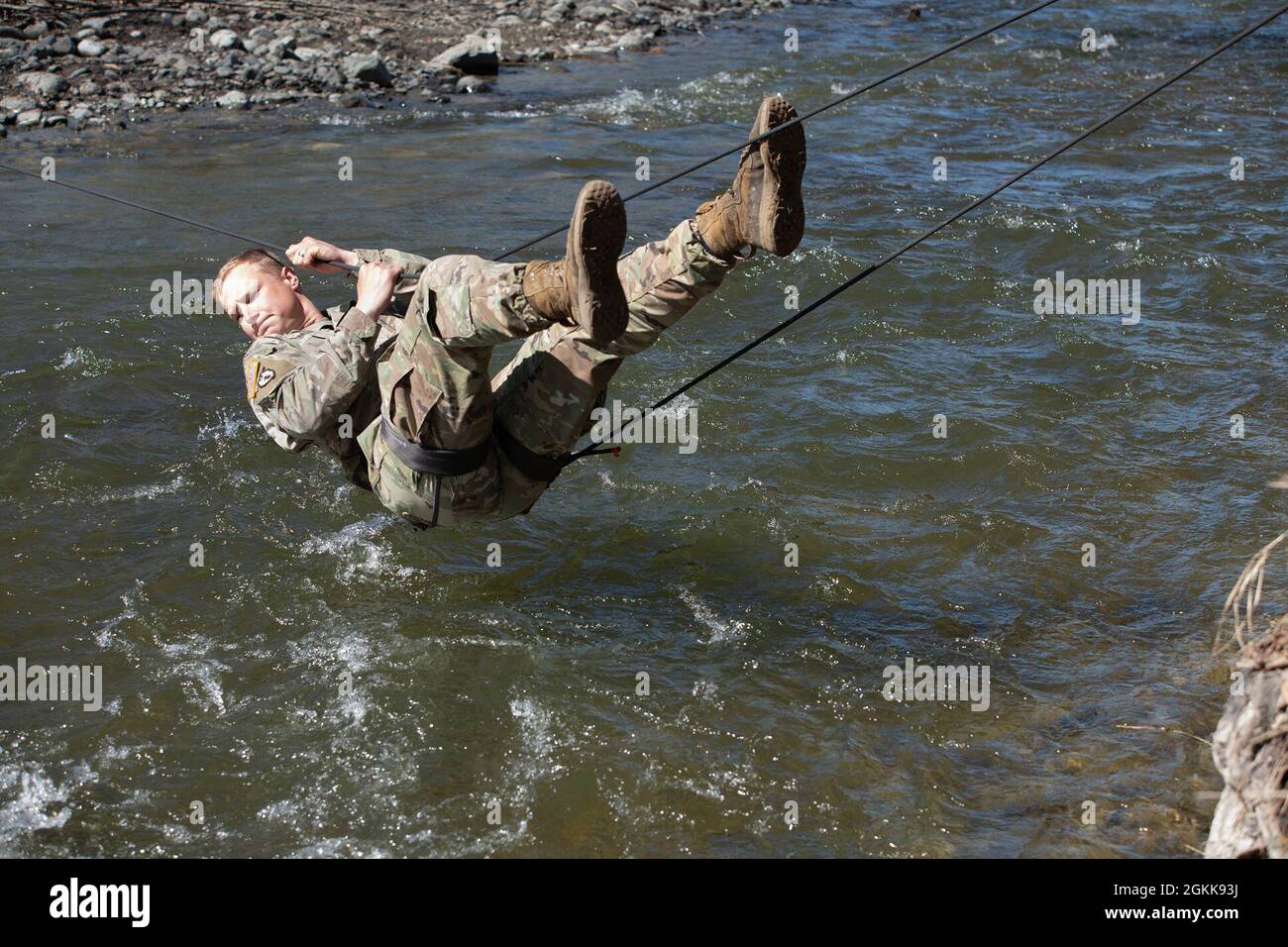 Sgt. James Mercer Hutton crosses a water obstacle using the one-rope bridge. The Soldiers from A Troop, 1st Squadron (Airborne), 40th Cavalry Regiment took advantage of a beautiful spring day to practice river crossing techniques over Ship Creek on Joint Base Elmendorf-Richardson May 13, 2021.  (Army photo/John Pennell) Stock Photo