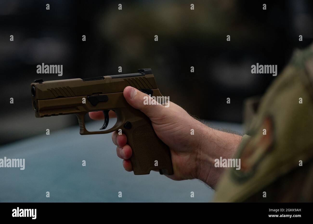 A u s air force service member holds a sig sauer p320 m18 pistol