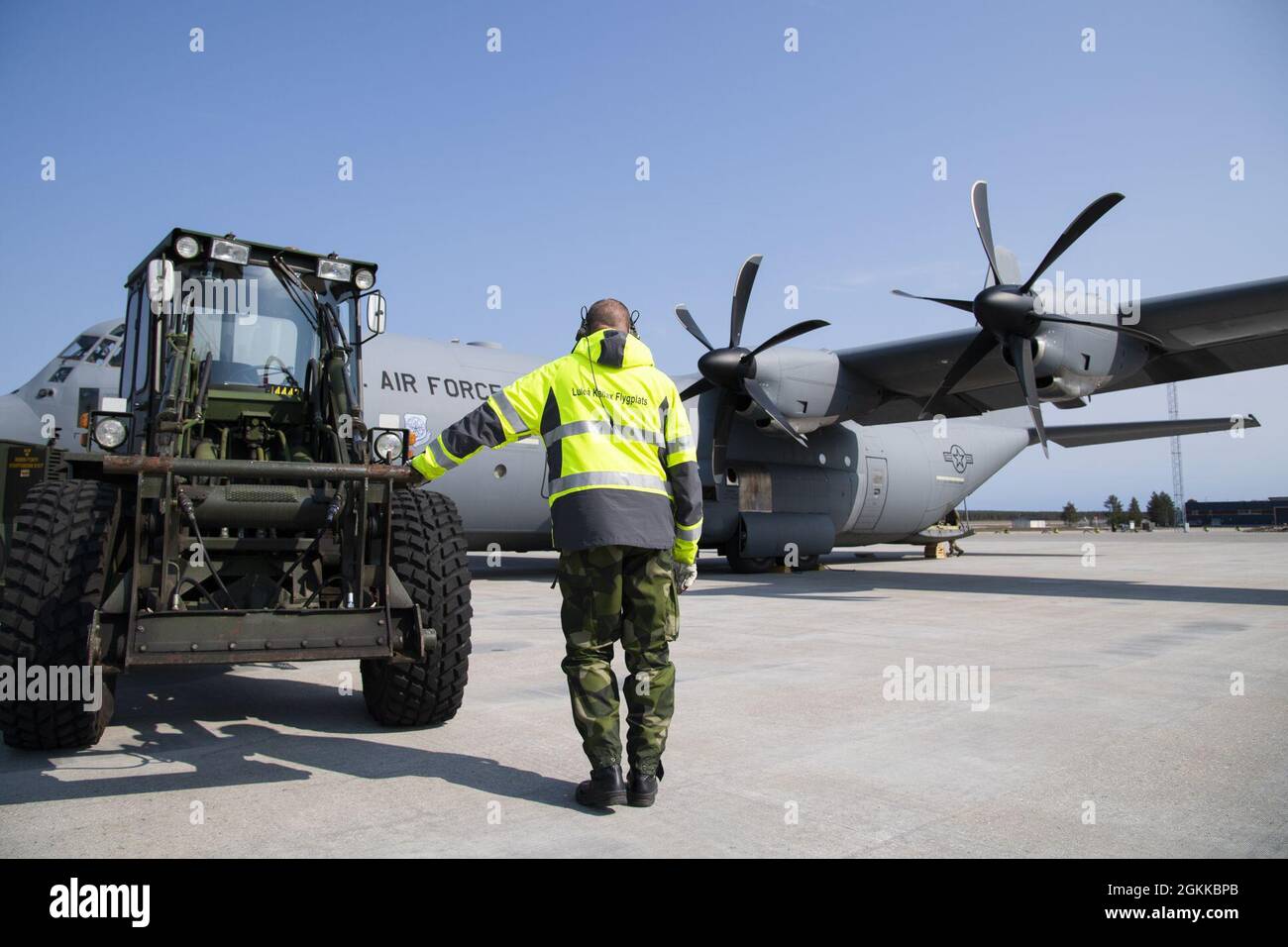 A member of the Swedish air force waits to unload cargo from a U.S. Air Force C-130 Hercules aircraft at Kallax Air Base, Sweden, May 14, 2021. Members of the Swedish air force provided support for U.S. Air Force Airmen during the Arctic Challenge Exercise 2021, a reoccurring exercise that this year is Norwegian air force-led. Training with allies and regional partners in the Nordic region enhances flexibility and interoperability among ally and partner nations in the interest of strengthening combined response capabilities and demonstrating international resolve. Stock Photo