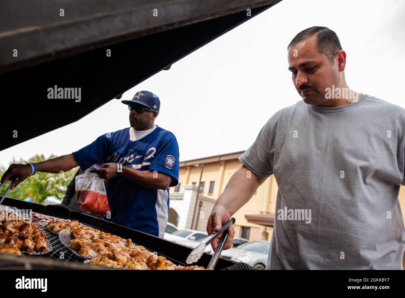Tech. Sgt. Joe Perkins, 51st Security Forces Squadron contingency operations section chief, left, and Master Sgt. Alejandrino Herrera, 51st SFS commander support staff superintendent, prepares food for the Police Week Morale Cookout at Osan Air Base, Republic of Korea, May 13, 2021. The cookout was open to all base personnel and host nationals, and finished off the week full of events with an afternoon of morale building and relaxation. Stock Photo