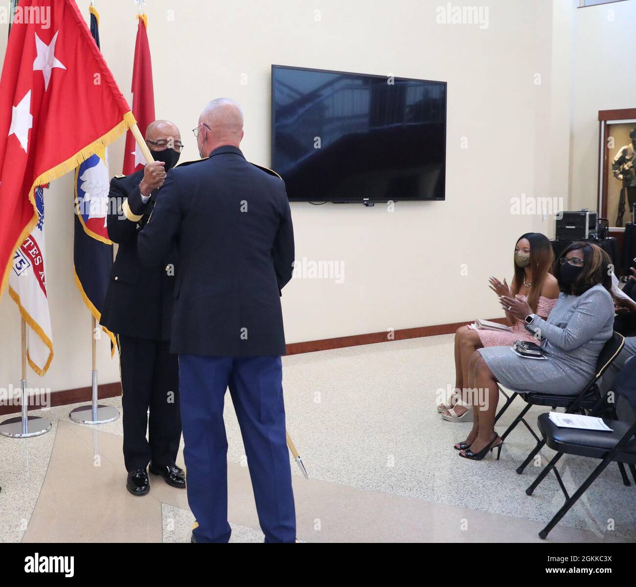 U.S. Army Reserve Lt. Gen. A.C. Roper receives the three-star flag from Command Sergeant Major (Ret) Jeffrey Darlington symbolizing promotion to the rank of lieutenant general during a promotion and oath of office ceremony for Roper at Fort Bragg, N.C., May 14, 2021.  In the early 20th century the War Department designed the flags for their generals and admirals. Red flags with white stars were for the Army; navy blue for the Navy; scarlet, for the Marines; and more recently, ultramarine blue for the Air Force. Today, it is customary for the general’s flag to be posted outside his or her offic Stock Photo