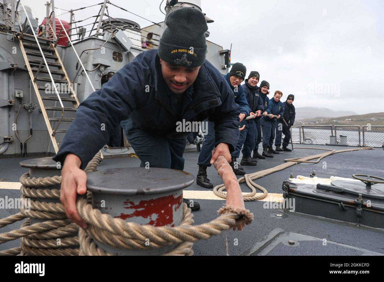 RUNAVIK, Faroe Islands (May 15, 2021) Sonar Technician (Surface) 2nd Class Julian Nelson, stationed aboard the Arleigh Burke-class guided-missile destroyer USS Ross (DDG 71), doubles up a line during a sea and anchor detail to pull the ship into port in the Faroe Islands, May 15, 2021. Ross, forward-deployed to Rota, Spain, is on patrol in the U.S. Sixth Fleet area of operations in support of regional allies and partners and U.S. national security interests in Europe and Africa. Stock Photo
