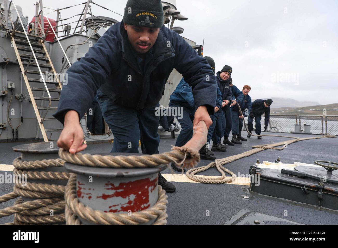 RUNAVIK, Faroe Islands (May 15, 2021) Sonar Technician (Surface) 2nd Class Julian Nelson, stationed aboard the Arleigh Burke-class guided-missile destroyer USS Ross (DDG 71), doubles up a line during a sea and anchor detail to pull the ship into port in the Faroe Islands, May 15, 2021. Ross, forward-deployed to Rota, Spain, is on patrol in the U.S. Sixth Fleet area of operations in support of regional allies and partners and U.S. national security interests in Europe and Africa. Stock Photo