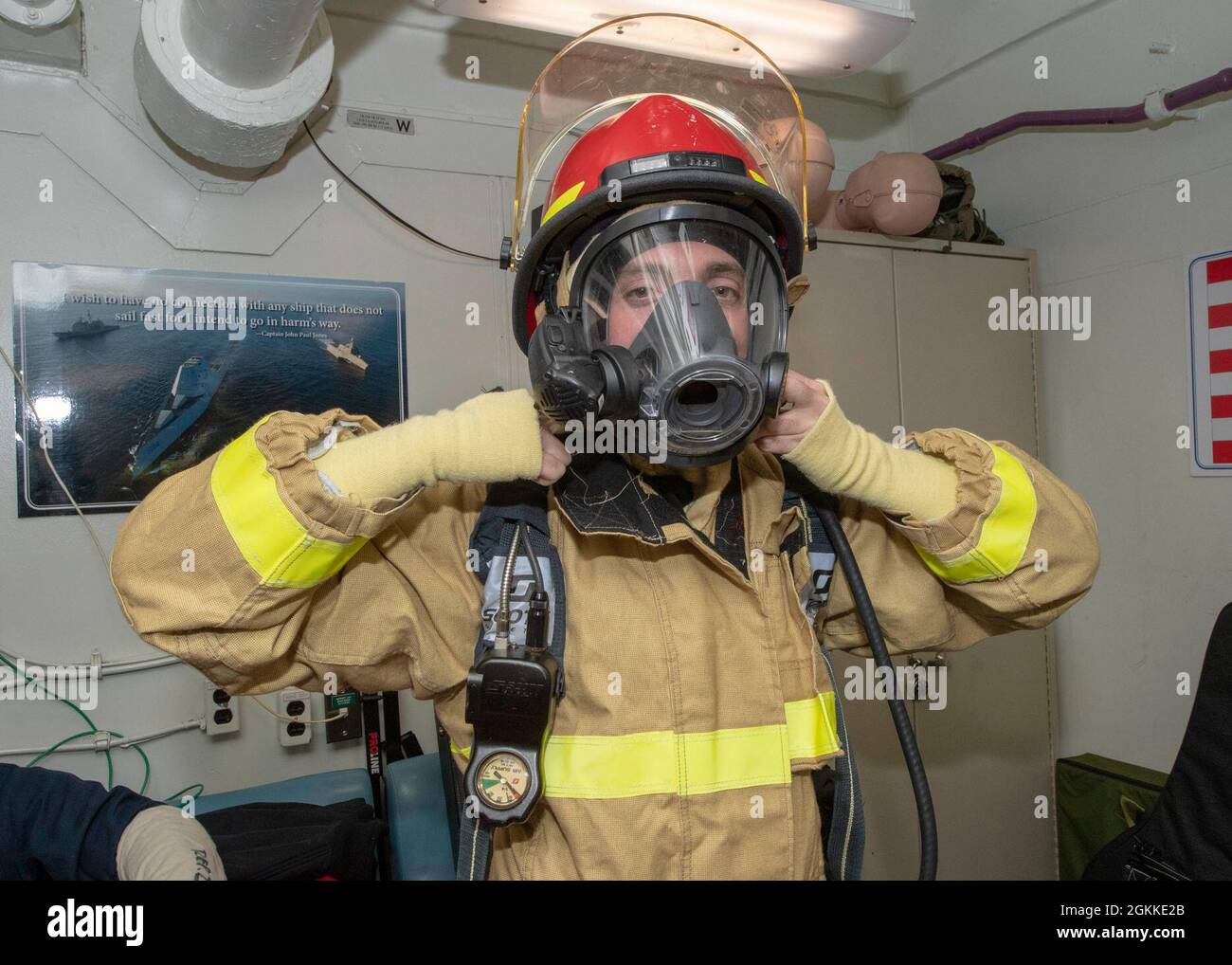 PACIFIC OCEAN (May 15, 2021) U.S. Navy Electronics Technician 3rd Class Bradley Sipes, from San Diego, puts on firefighting gear during a damage control drill aboard the Ticonderoga-class guided-missile cruiser USS Bunker Hill (CG 52) May 15, 2021. Bunker Hill, part of the Theodore Roosevelt Carrier Strike Group, is on a scheduled deployment conducting routine operations in U.S. 3rd Fleet. Stock Photo