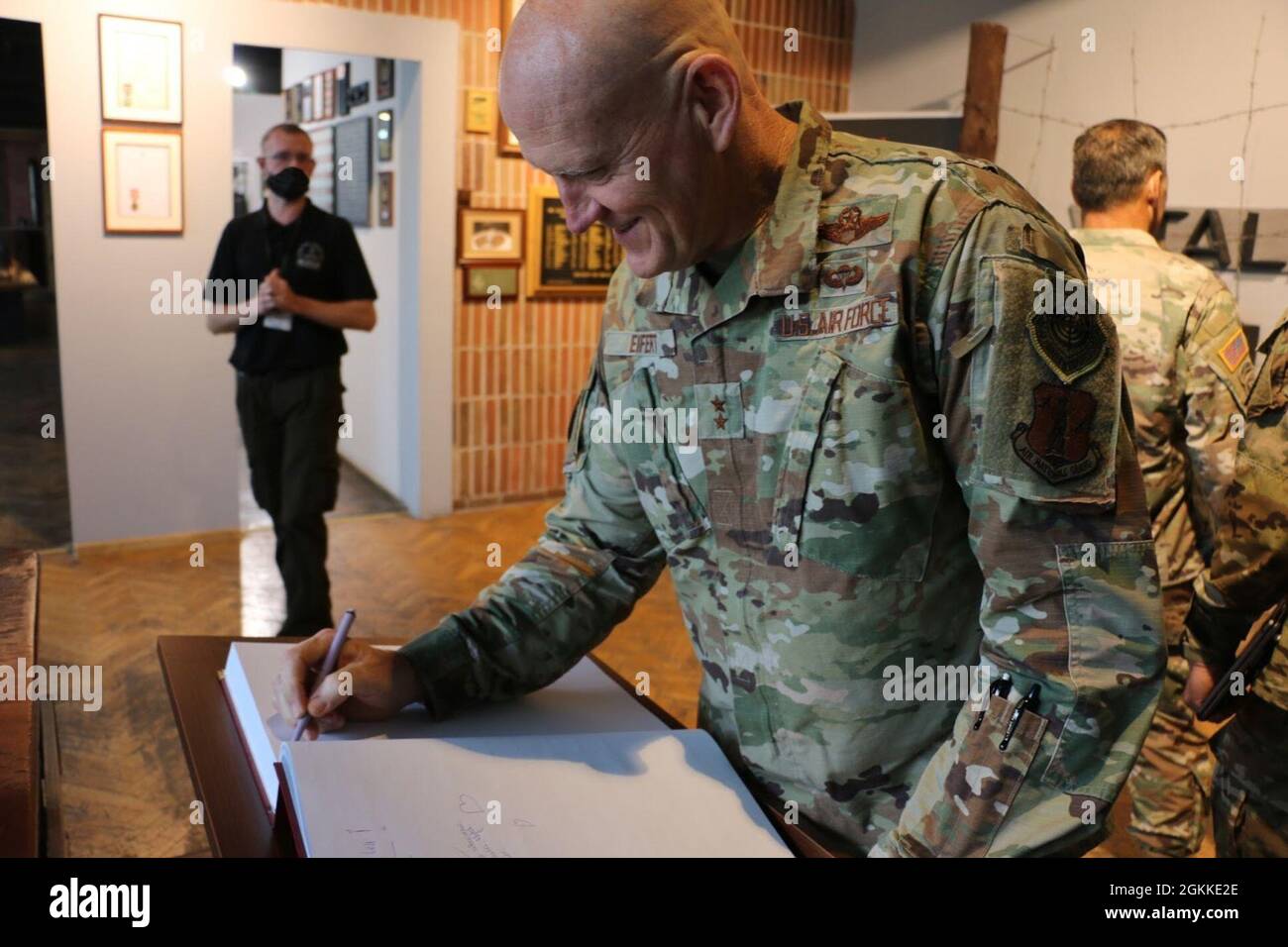 Air Force Maj. Gen. James Eifert (right), Florida National Guard adjutant general, signs the guest book while touring the Prisoner of War Camps Museum at the site of Stalag Luft III during a command visit to soldiers deployed with the 50th Regional Support Group (RSG) in Zagan, Poland, on May 16, 2021. This museum preserves the memory of the “Great Escape” of 1944 during World War II. The plan for the “Great Escape” called for a maximum of 200 Allied prisoners of war to break free from Stalag Luft III, but only 76 airmen escaped, and of those, only three avoided recapture by German forces. Stock Photo