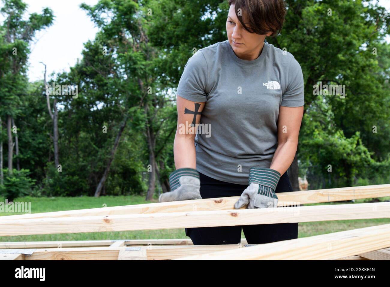 U.S. Army Reserve Sgt. 1st Class Crystal Rowland, a mobilization data reports noncommissioned officer assigned to the Mobilization Demobilization Operations Center (MDOC) from the 2-381st Training Support Battalion, 120th Infantry Brigade, Division West, carries a piece of wood framing while volunteering for a Habitat for Humanity housing project in Waco, Texas, May 16, 2021.  Rowland, who has ties to the Waco community, was instrumental to organizing this volunteering effort for her team. Stock Photo