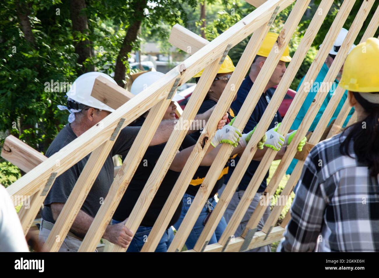 U.S. Army Reserve Soldiers assigned to the Mobilization Demobilization Operations Center (MDOC) from the 2-381st Training Support Battalion, 120th Infantry Brigade, Division West, along with other volunteers, assist with moving lumber during a Habitat for Humanity housing project in Waco, Texas, May 16, 2021.  The participants from the MDOC team used this volunteering opportunity to frame a creative way for team building and leadership development, while also supporting the local community. Stock Photo