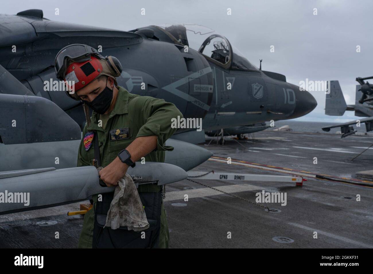 PACIFIC OCEAN (May 15, 2021) U.S. Marine Corps Lance Cpl. Angel Centeno, an aviation ordnanceman assigned to Marine Attack Squadron (VMA) 214, 11th Marine Expeditionary Unit (MEU), from Modesto, Calif., conducts maintenance on an AV-8B Harrier on the flight deck of amphibious assault ship USS Essex (LHD 2), May 16. Sailors and Marines of the Essex Amphibious Ready Group (ARG) and the 11th MEU are underway off the coast of southern California. Stock Photo