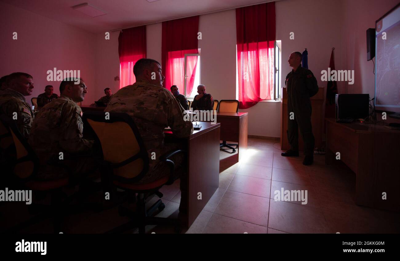 (FARKE AIRFIELD, Albania) --- American and Albanian pilots focus their attention on the presenter during a pre-flight brief, May 18, 2021. This meeting helped build readiness and interoperability between the different military forces participating in DEFENDER-Europe 21. Stock Photo